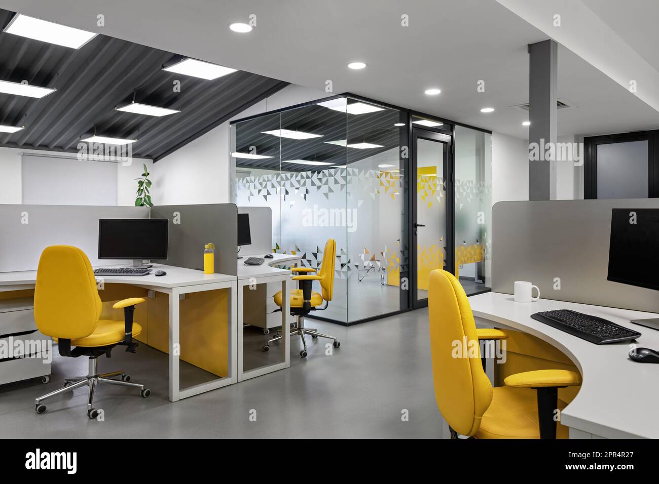 Ufficio IT con postazioni di lavoro per sviluppatori di dipendenti con sedie gialle. Computer per sala di codifica. Foto Stock