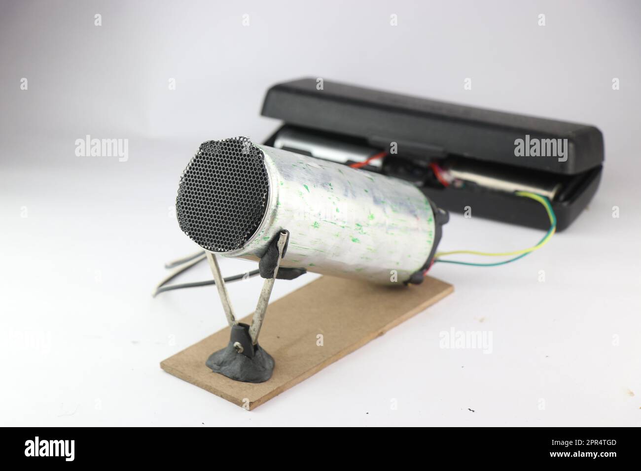 Dispositivo di riscaldamento dell'aria realizzato con materiali riciclati e elemento riscaldante alimentato dalla batteria su sfondo bianco. Invenzioni fatte in casa Foto Stock
