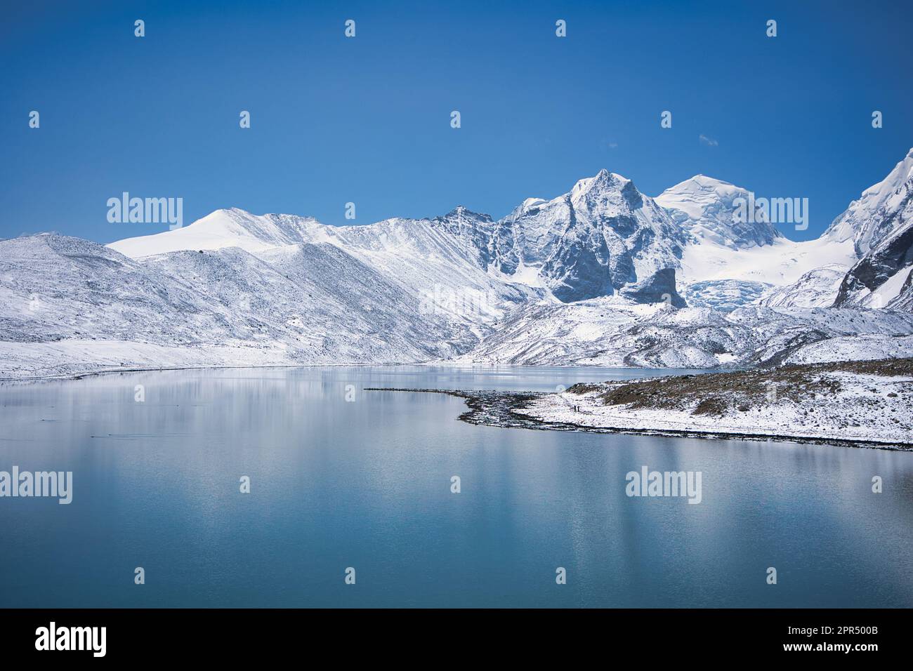 Il lago Gurudongmar, coperto di neve e con una splendida vista sul lago, è uno dei posti migliori da visitare e da godere durante le vacanze. Montagne innevate con fiato Foto Stock