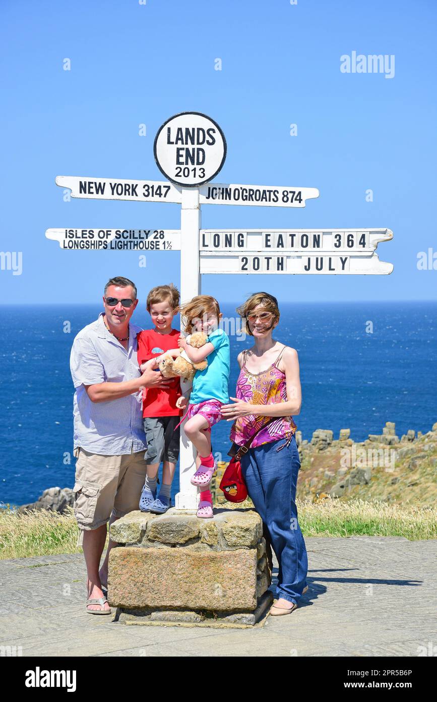 Foto di famiglia a distanza cartello al Land's End, penisola di Penwith, Cornwall, England, Regno Unito Foto Stock