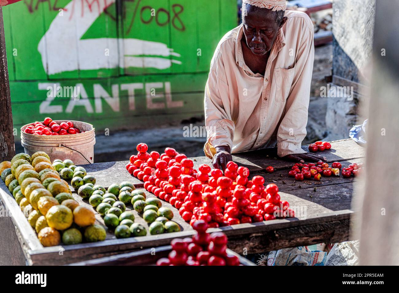 Uomo che vende frutta in un mercato, Zanzibar, Tanzania Foto Stock