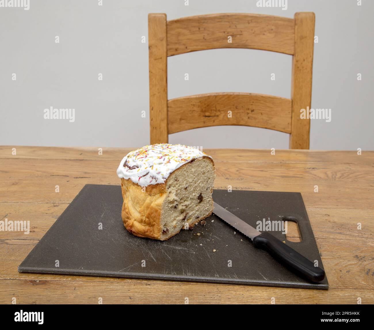 Cibo tradizionale ucraino di Pasqua, Paska, pane di frutta ghiacciato. Anche Kulich nella tradizione russa. Coltello per pane sul tritare. Foto Stock