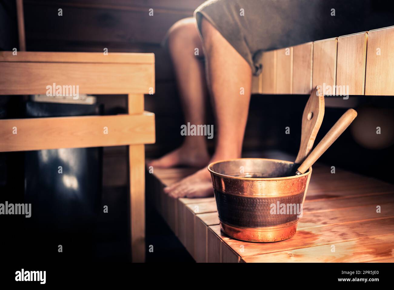 Sauna e uomo in Finlandia. Bagno turco con vasca idromassaggio in legno. Cabina estiva finlandese o hotel. Persona con asciugamano. Terapia calda e sana per le persone. Foto Stock