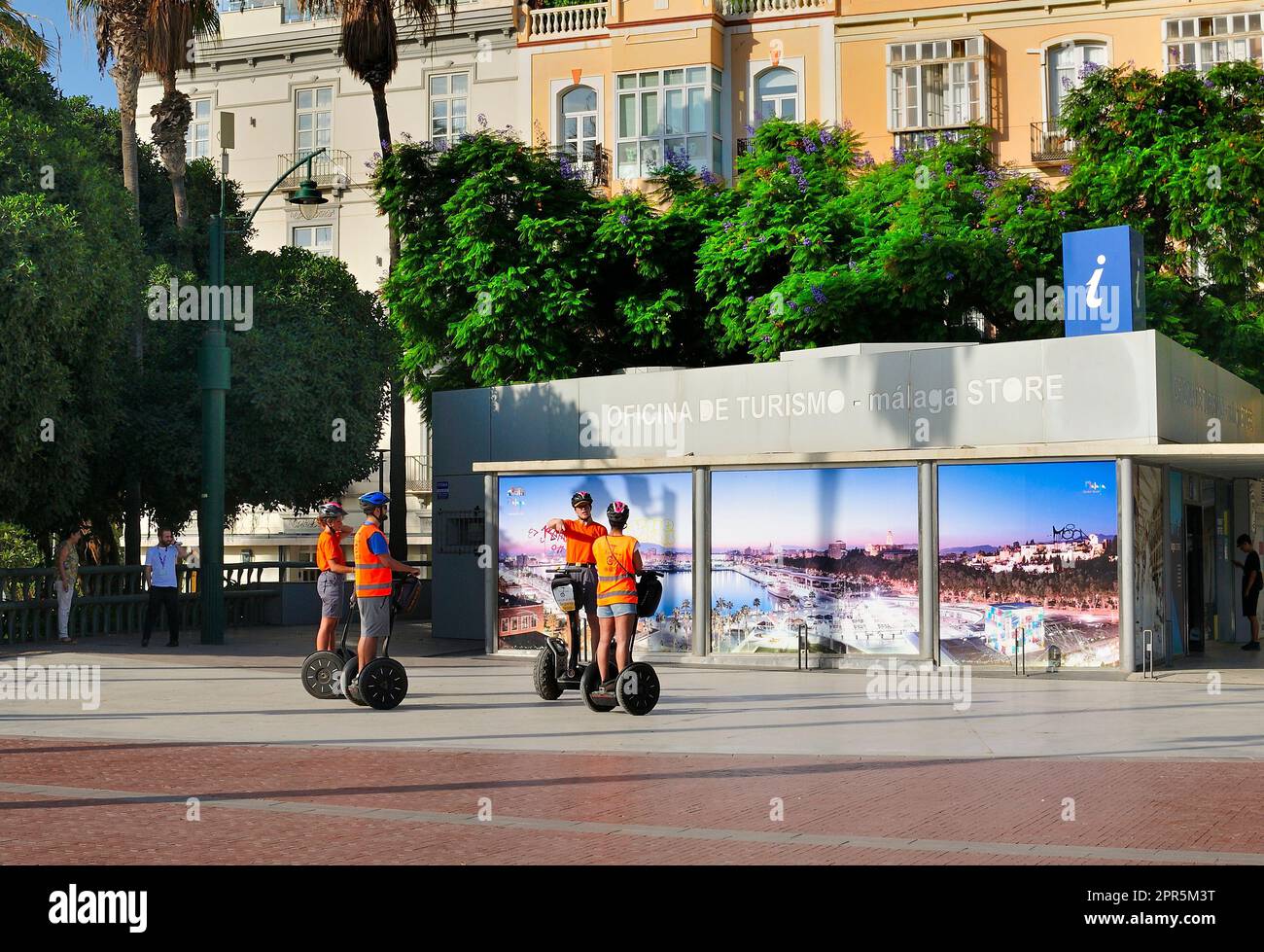 Un gruppo di turisti che riceve istruzioni sull'uso del segway dei veicoli elettrici a due ruote al di fuori dell'ufficio turistico della città di Malaga Foto Stock