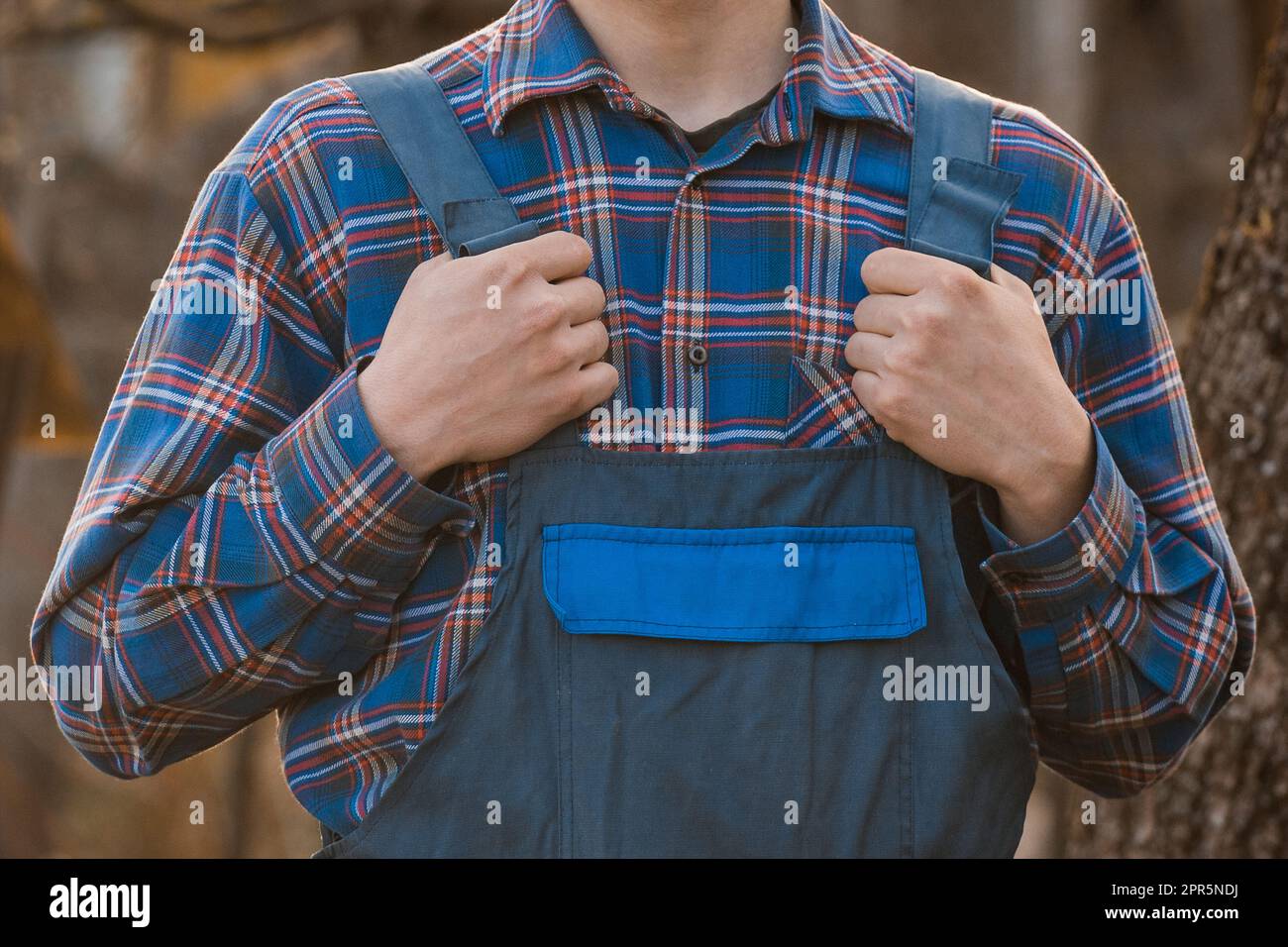 Abbigliamento del coltivatore o del giardiniere aspetto Moda camicia blu modellato tuta mani Jumpsuit a scacchi. Foto Stock