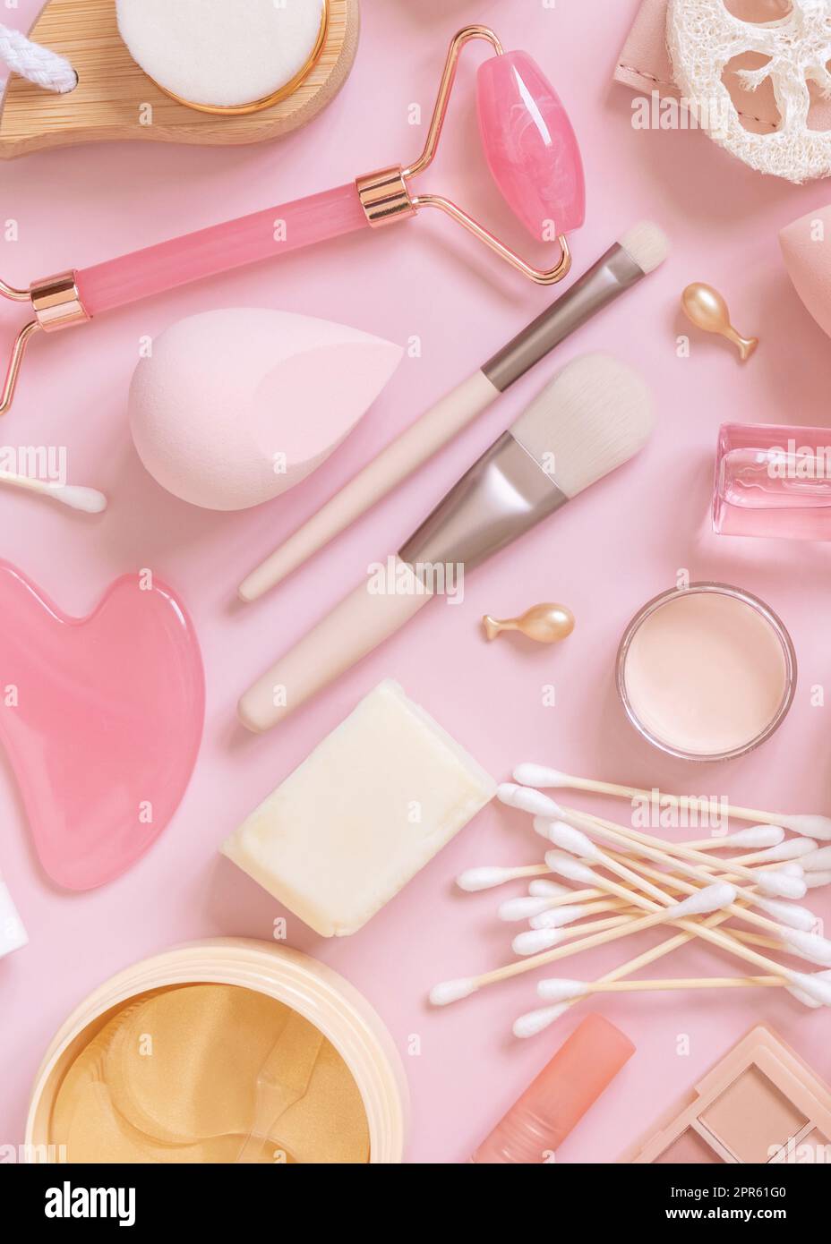 Prodotti per la cura della pelle e il trucco su rosa chiaro, vista dall'alto. Flat Lay con prodotti di bellezza naturali e cosmetici decorativi. Quotidiano donna cura del viso routin Foto Stock