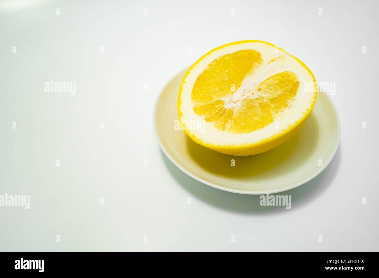 Immagine di pompelmo e piatto bianco Foto Stock