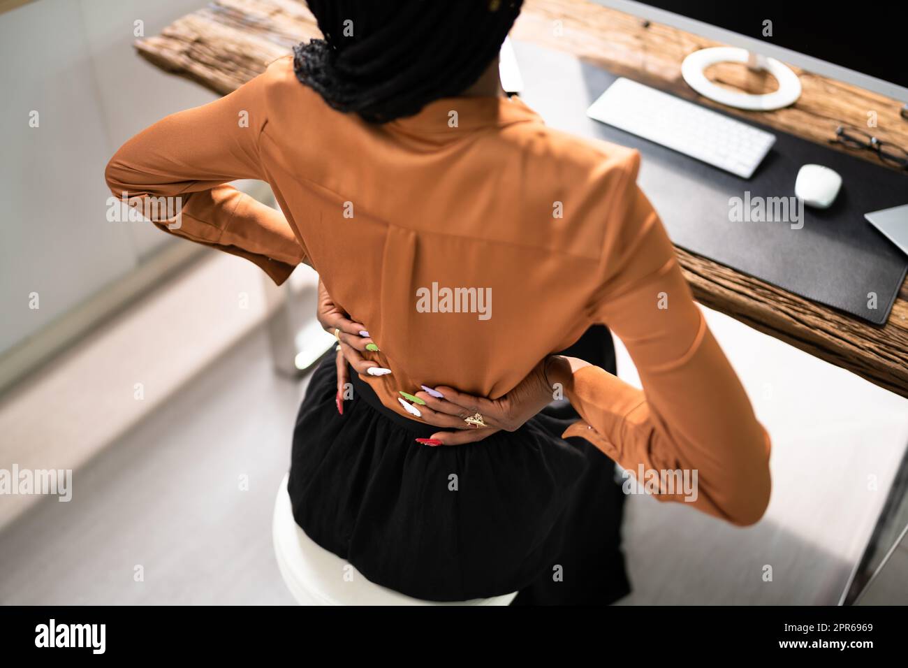 Donna d'affari che soffre di mal di schiena alla reception Foto Stock