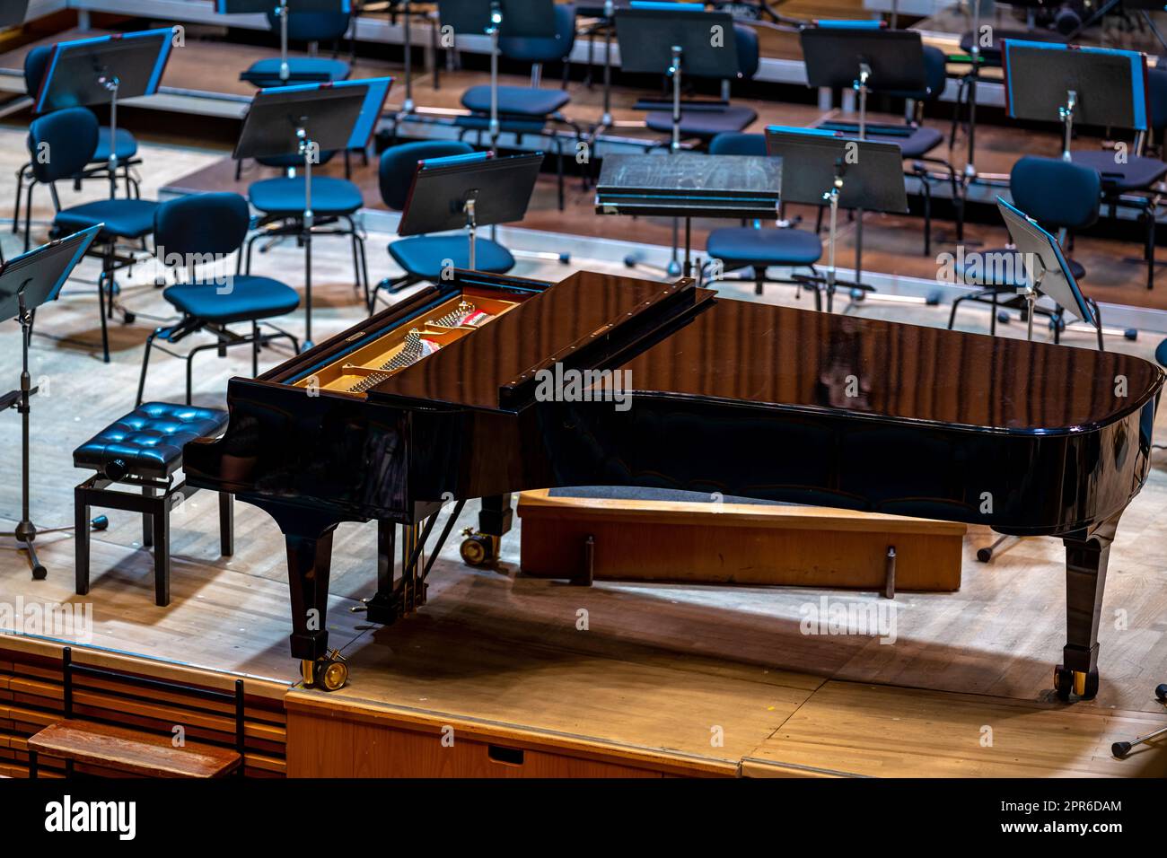 Un pianoforte sul palco della Filarmonica tra gli altri strumenti musicali Foto Stock