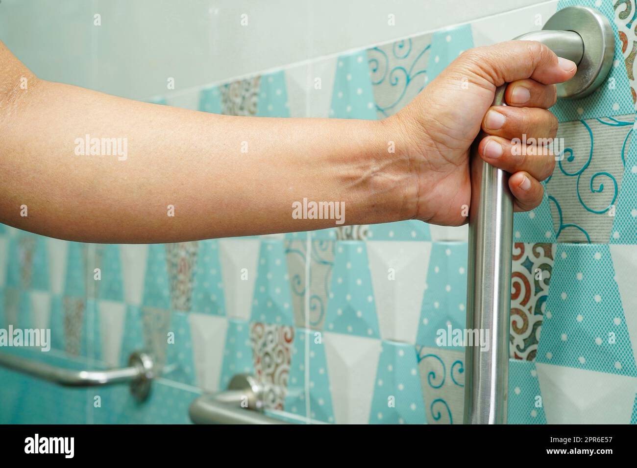 Donna asiatica paziente uso servizi igienici sostegno in bagno, corrimano di sicurezza maniglia bar, sicurezza in ospedale di cura. Foto Stock