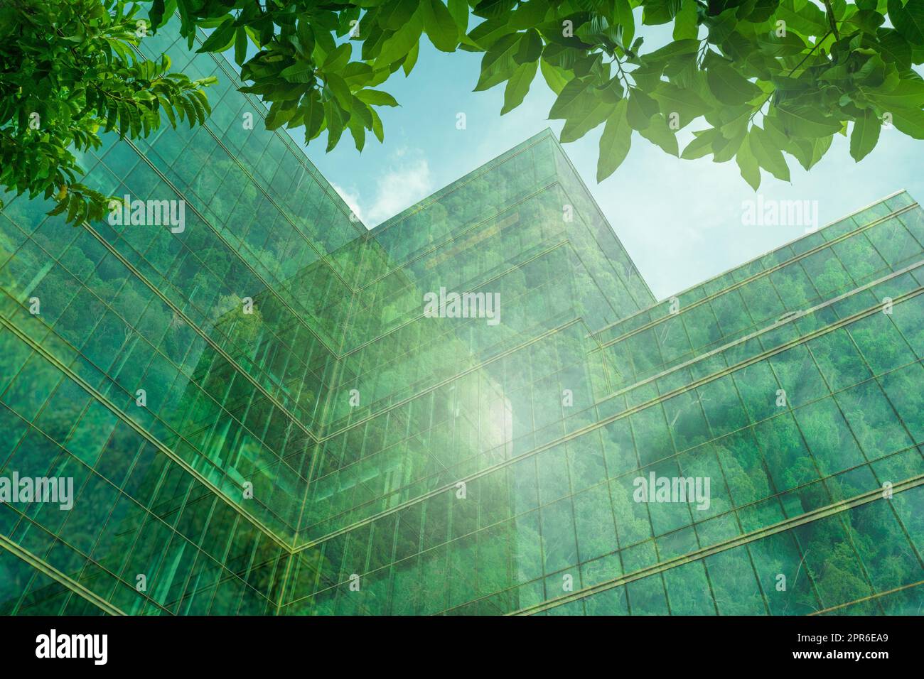 Edificio ecologico nella città moderna. Edificio sostenibile in vetro per uffici con alberi per ridurre il calore e l'anidride carbonica. Edificio di uffici con ambiente verde. Riduzione degli edifici aziendali CO2. Foto Stock