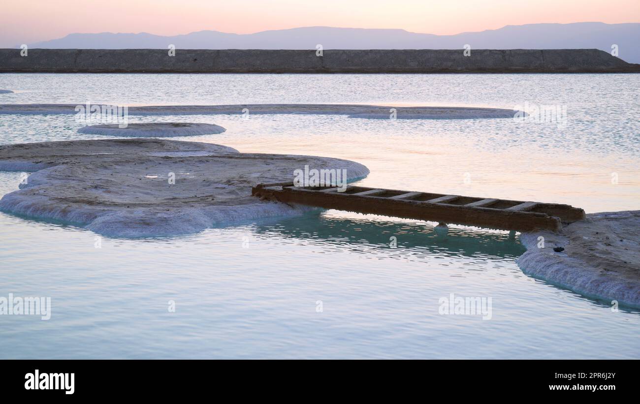 Una scala posta tra due isole di sale al Mar Morto. Divertimento al mare Foto Stock