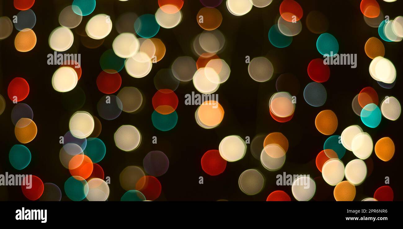 Lo sfondo natalizio è un tavolo scuro e luci multicolore sfocate sullo sfondo. Foto Stock