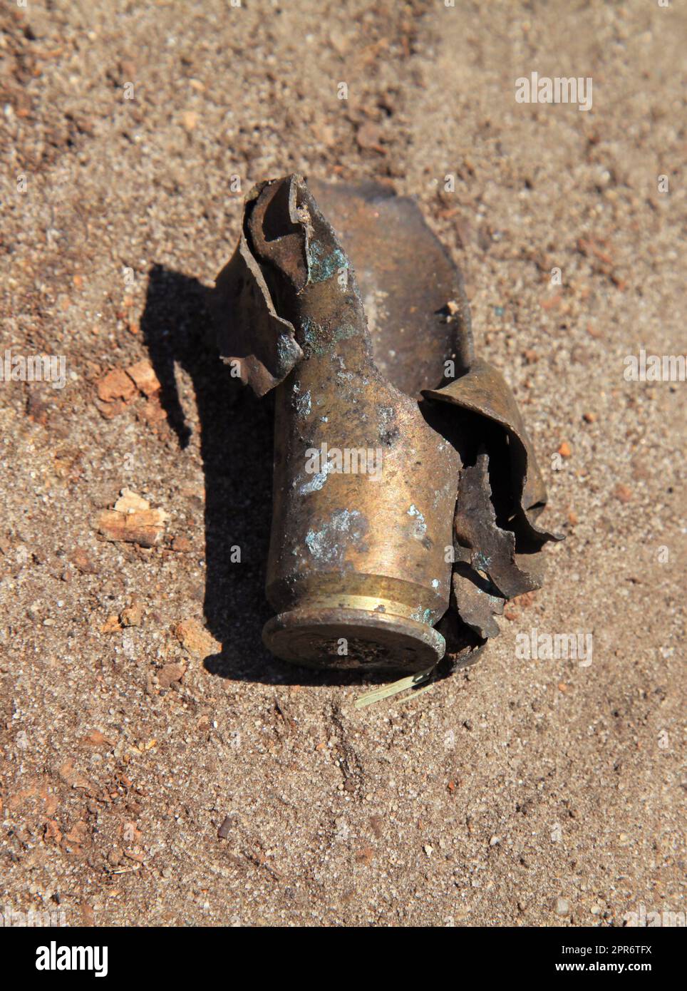 Esploso e bruciato l'alloggiamento della cartuccia dopo lo shot. Primo piano sul campo di battaglia e sui resti di munizioni d'armi. Guerra nel paese Foto Stock