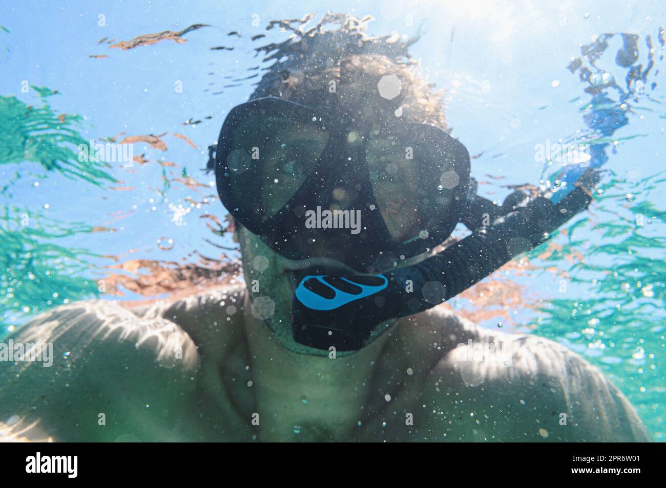 Uomo snorkeling con maschera subacquea in mare Foto Stock