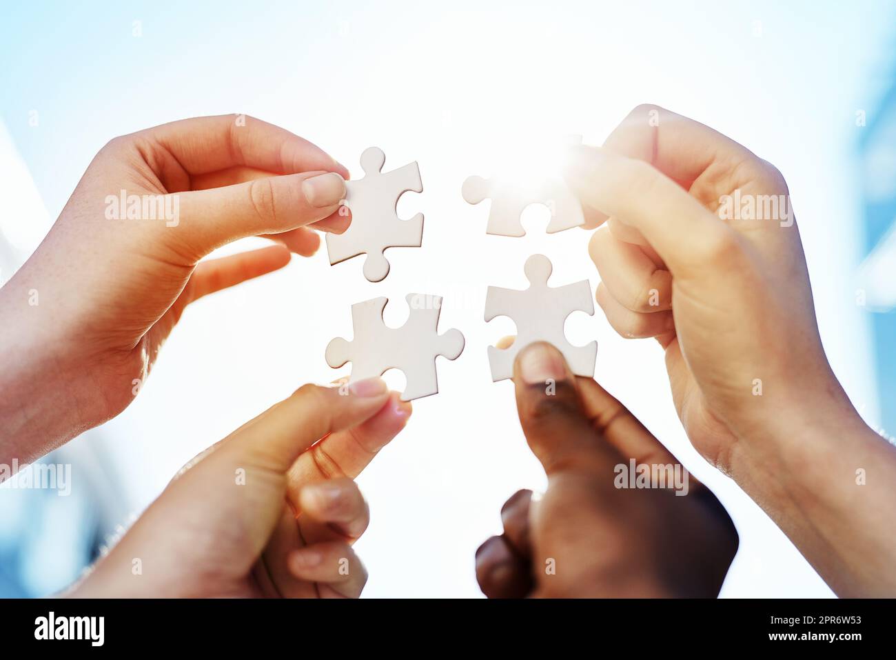Collegare i pezzi. Colpo di mani che mettono insieme pezzi di puzzle. Foto Stock