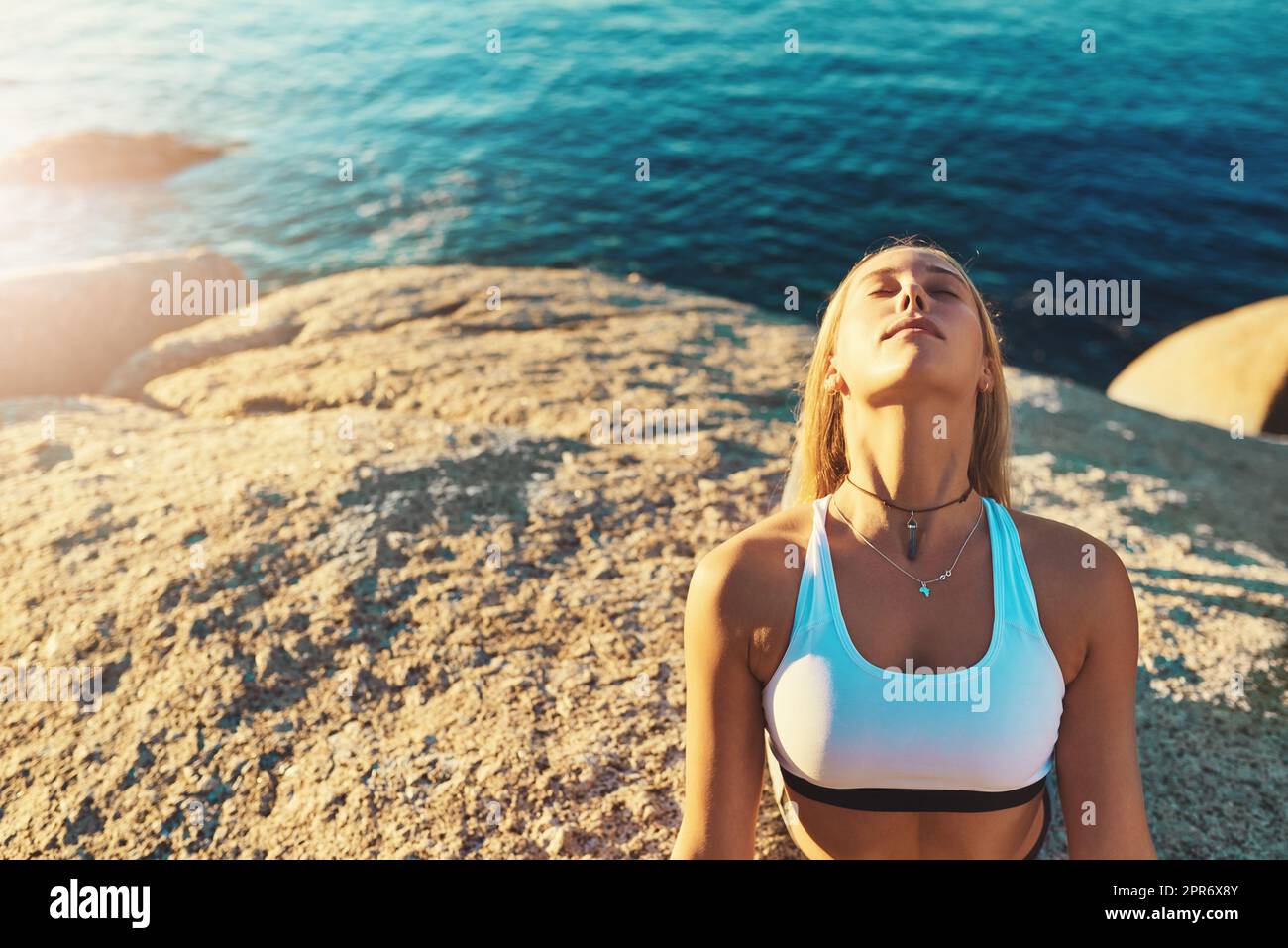 Io pratisco lo yoga perché è buono per me. Shot di una giovane atletica che pratica yoga sulla spiaggia. Foto Stock