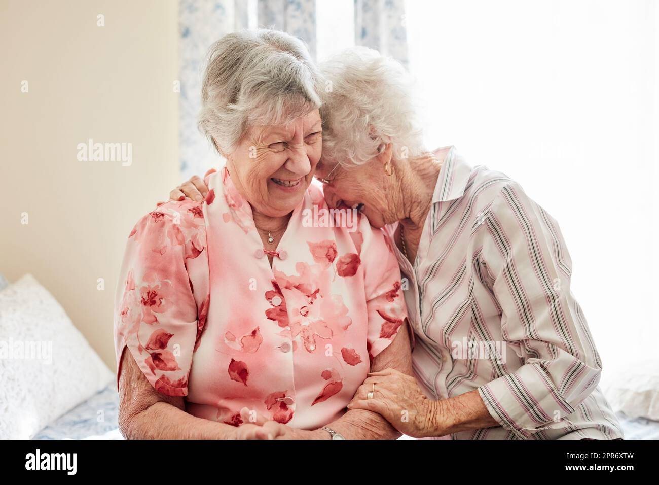 Niente ispira la felicità come un buon vecchio amico. Shot di due donne anziane felici che si abbracciano a casa. Foto Stock