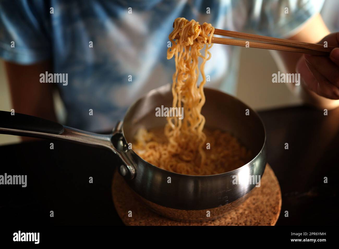 Mangiare spaghetti istantanei in pentola di alluminio Foto Stock
