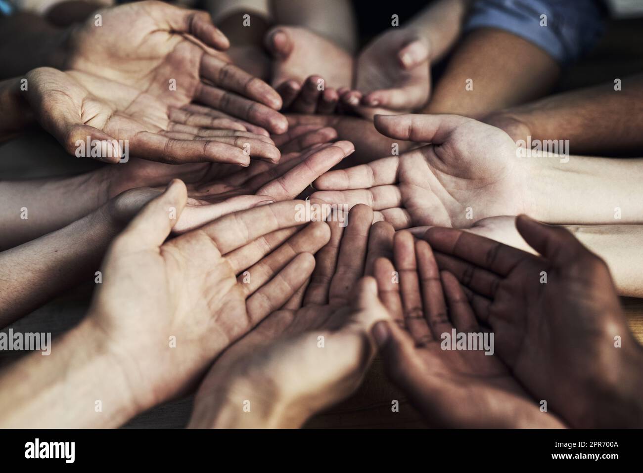 Tutti possono aiutare qualcuno. Scatto ritagliato di un grande gruppo di persone non identificabili che cupping le mani insieme. Foto Stock