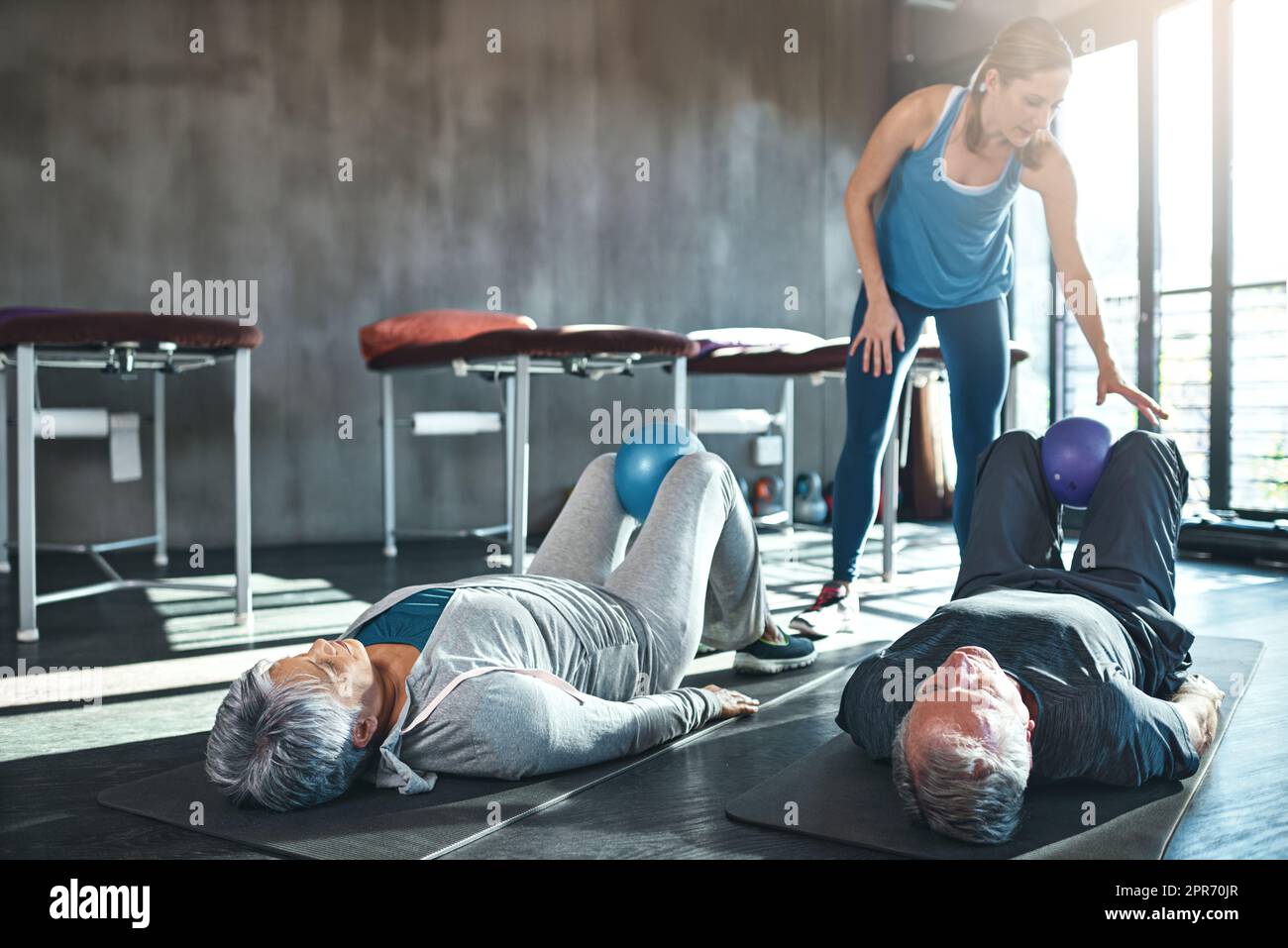 Pensionato, non stanco. Shot di due anziani che si allenano con un fisioterapista. Foto Stock