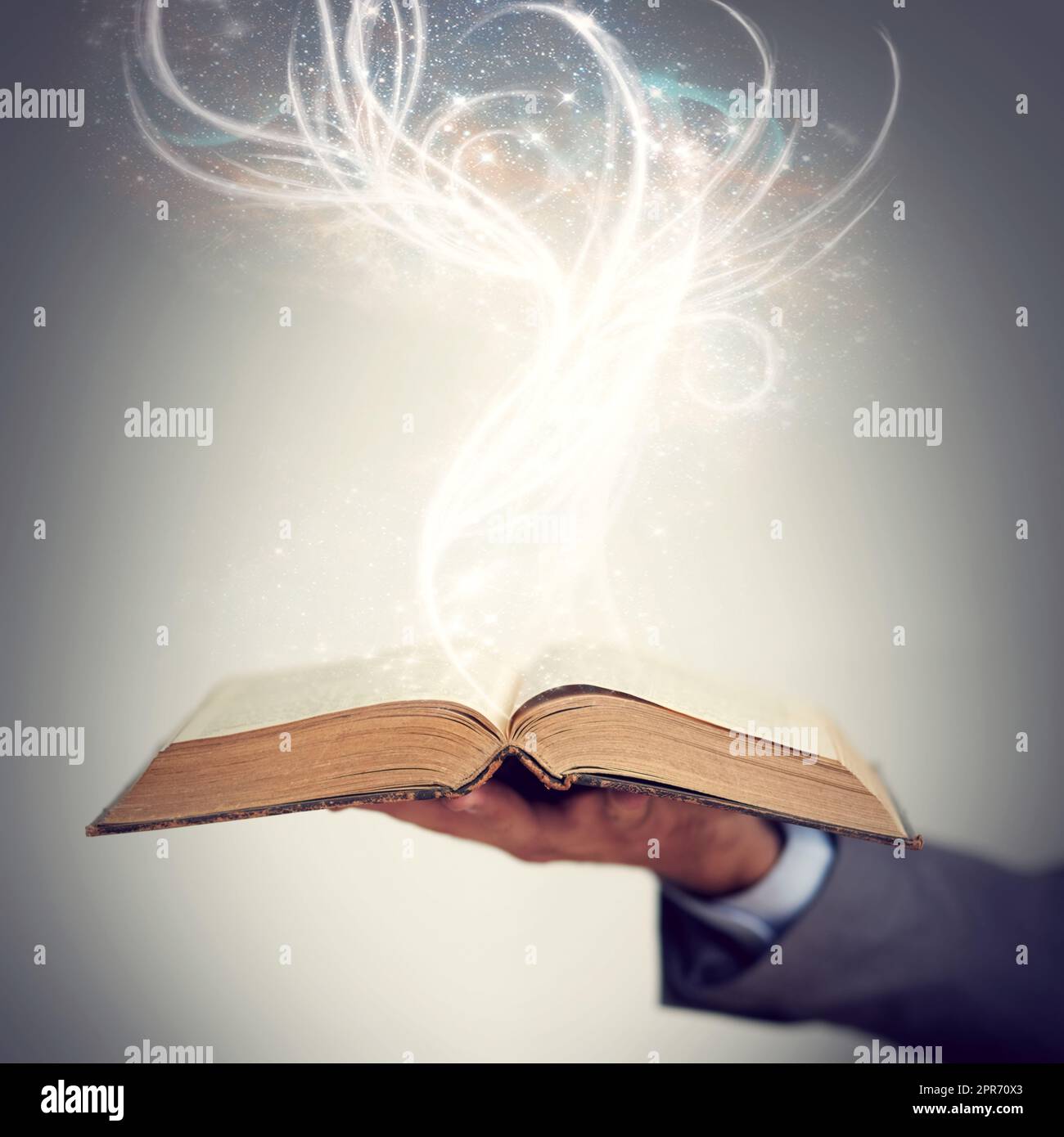 L'alfabetizzazione è un dono che continua a dare. Scatto di una mano che tiene uno storybook aperto con la luce che emana da esso. Foto Stock