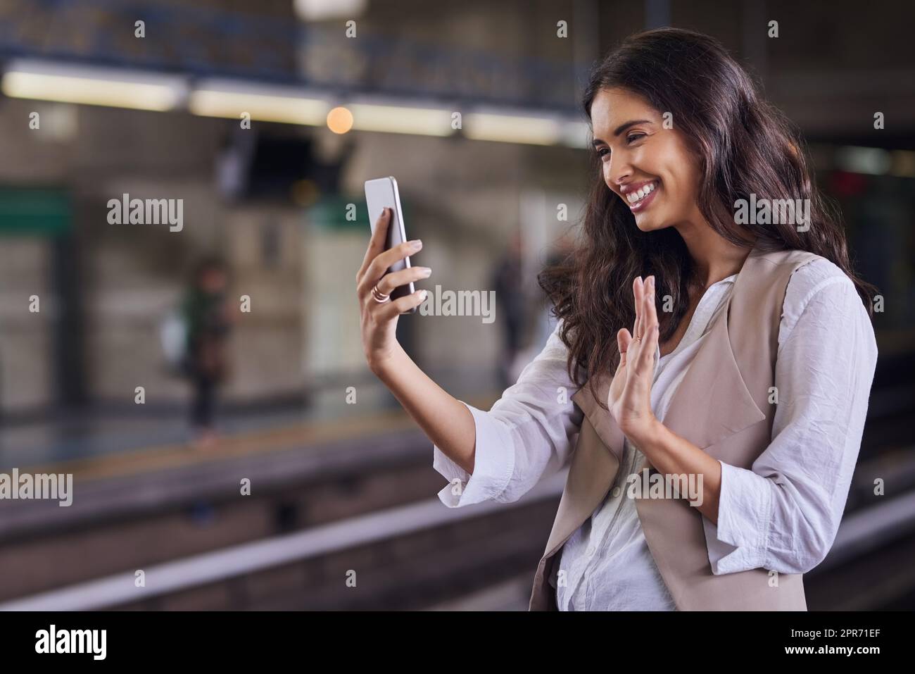 Salutando la gente di casa. Scatto corto di una giovane donna attraente videochiamata con il suo cellulare mentre si commuta con il treno. Foto Stock