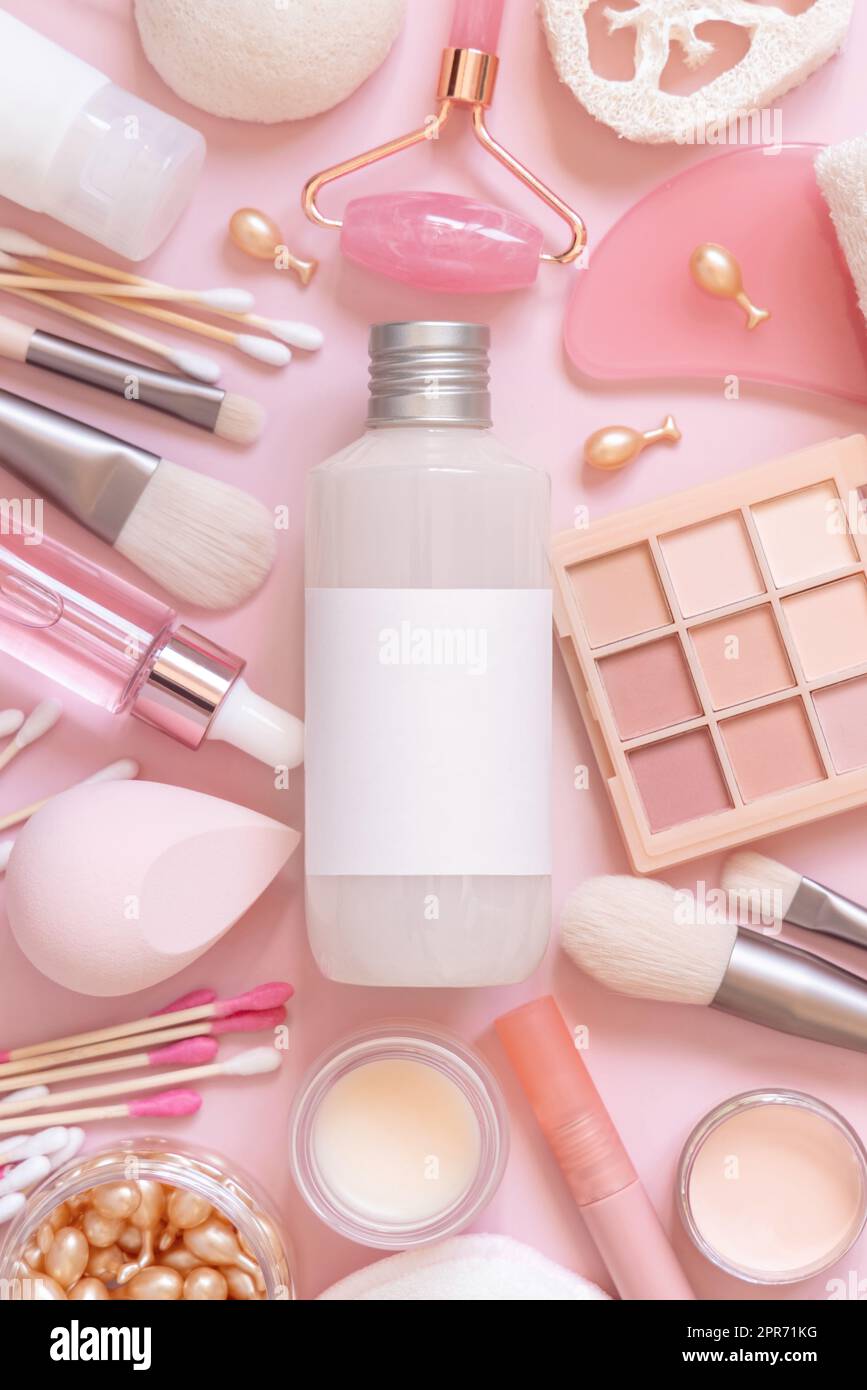 Bottiglia con etichetta blanik, cura della pelle e cosmetici decorativi rosa, vista dall'alto, mockup Foto Stock