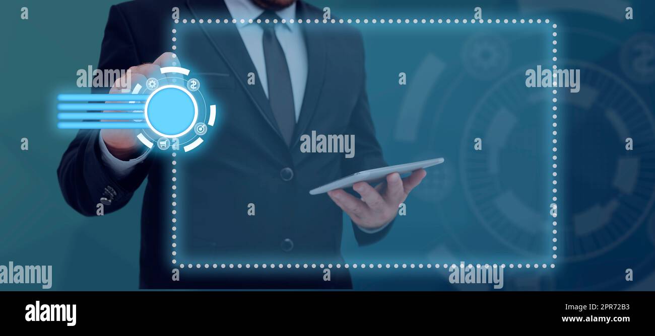 Uomo d'affari con tablet e penna che puntano sui simboli digitali che mostrano informazioni cruciali nel design futuristico. Uomo in tuta che presenta dati importanti e nuove idee al lavoro. Foto Stock