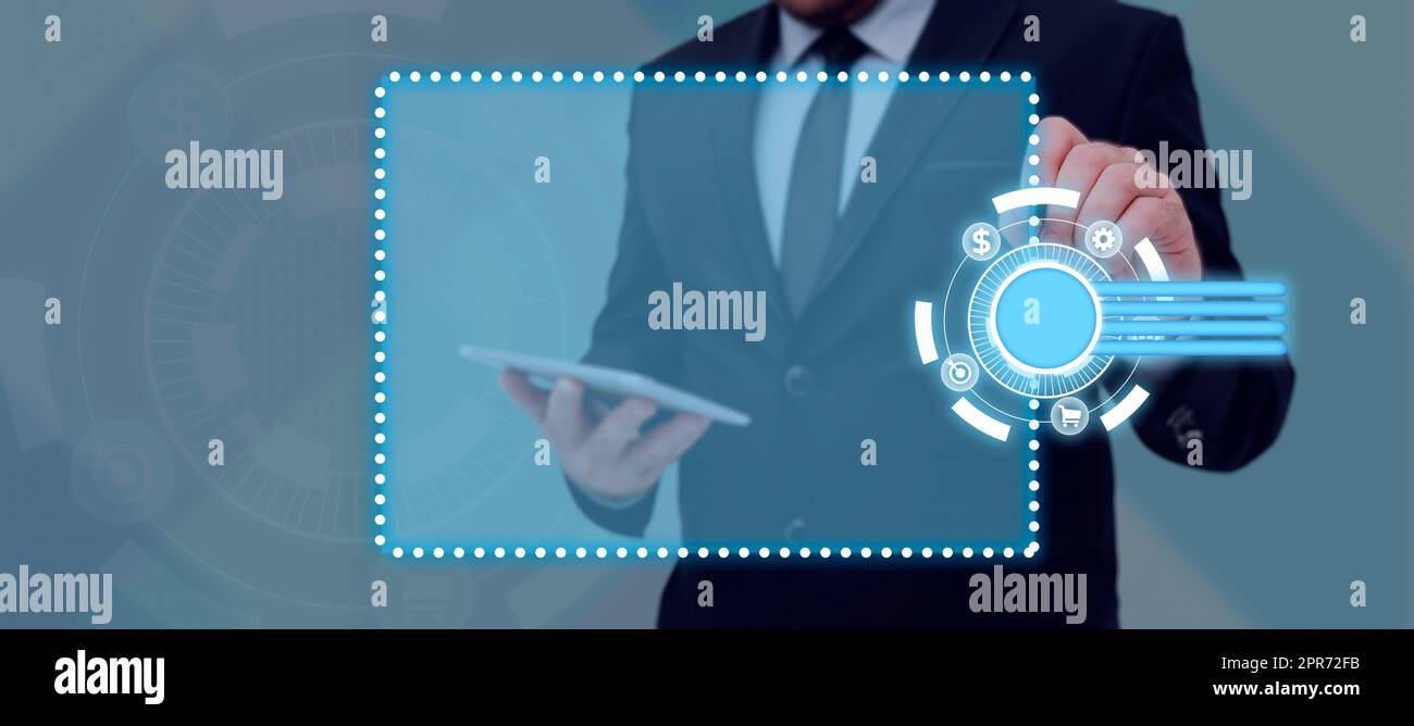 Uomo d'affari con tablet e penna che puntano sui simboli digitali che mostrano informazioni cruciali nel design futuristico. Uomo in tuta che presenta dati importanti e nuove idee al lavoro. Foto Stock