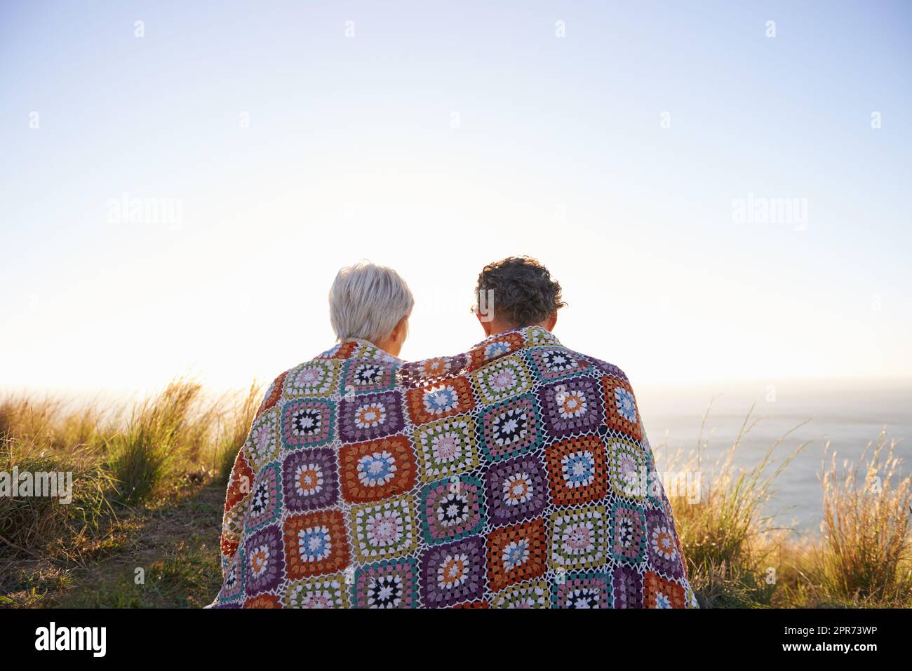 Romanticismo sulla collina. Vista di una coppia anziana seduta su una collina insieme. Foto Stock