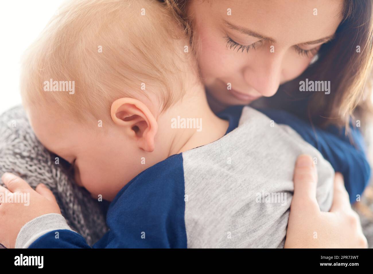 La mamma ti amerà sempre il mio piccolo angelo. Scatto corto di una madre che tiene il suo bambino assonnato a casa. Foto Stock