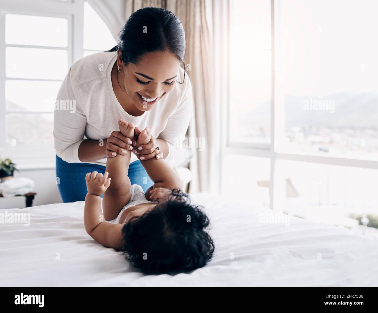 Consente di modificare questo pannolino. Scatto di una giovane donna attraente che si lega con il suo bambino a casa mentre cambia il suo pannolino. Foto Stock