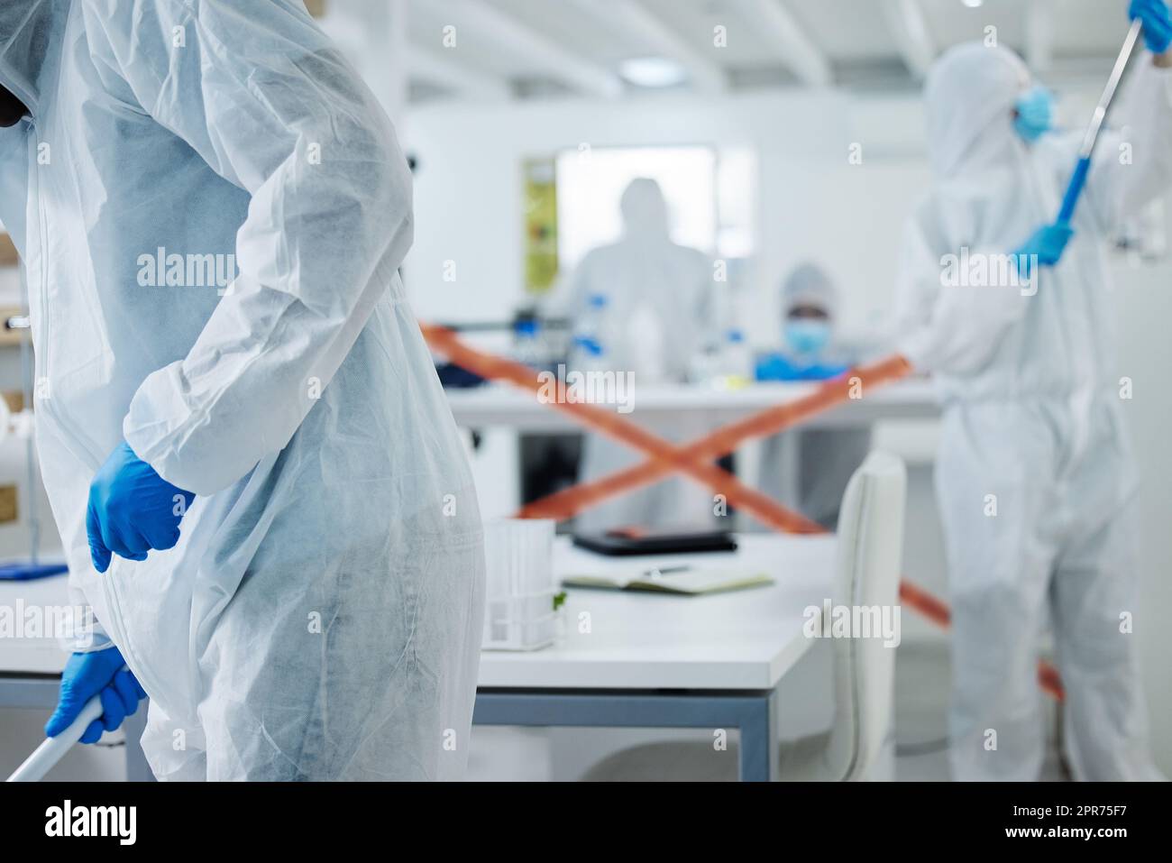 I suoi limiti off. Shot di un gruppo di scienziati che puliscono un disordine in un laboratorio. Foto Stock