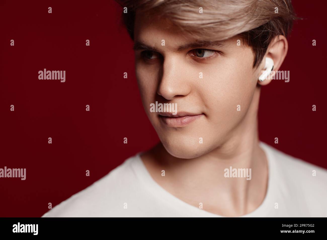 uomo in t-shirt bianca con auricolari moderni Foto Stock