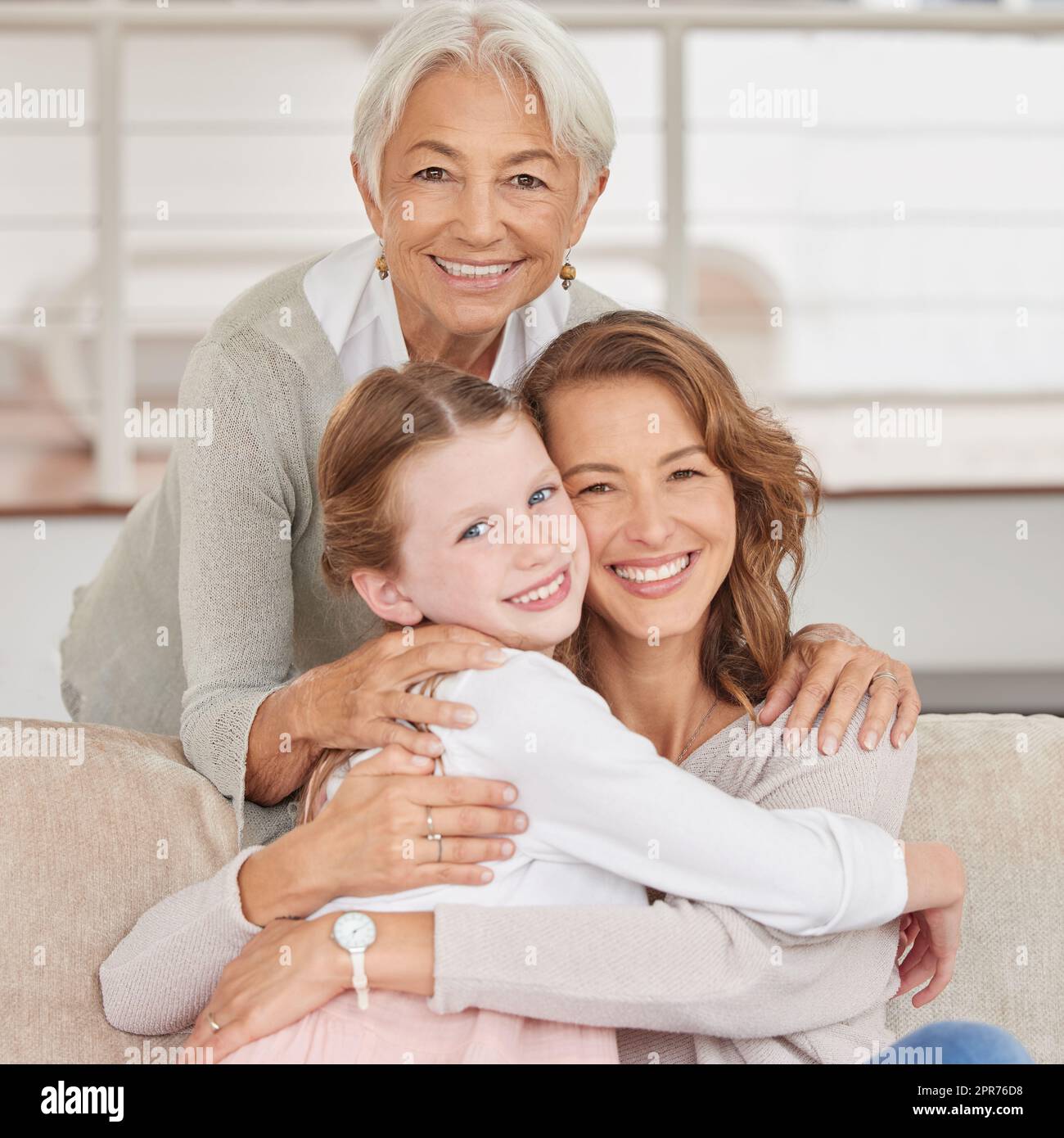 Ritratto di una nonna che si rilassa con sua figlia e sua madre. Bambina che si unisce con i genitori e i nonni nel salotto di casa. Tre generazioni che passano del tempo insieme Foto Stock