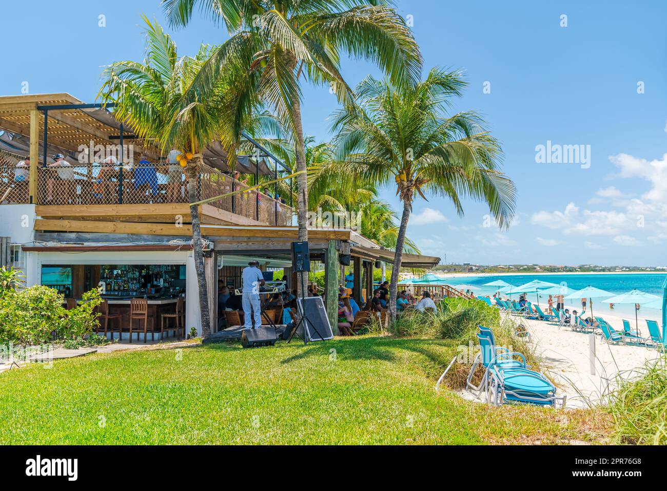Ristorante fronte spiaggia e palme lungo Grace Bay a Turks e Caicos. Foto Stock