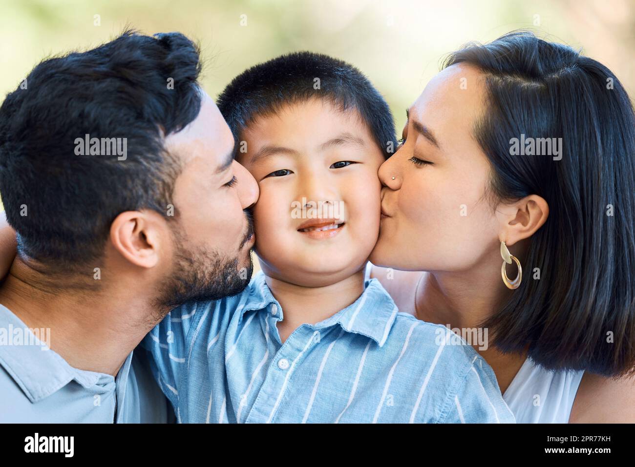 Mantieni i baci in arrivo. Scatto di un ragazzo adorabile baciato dai  genitori in un giardino Foto stock - Alamy