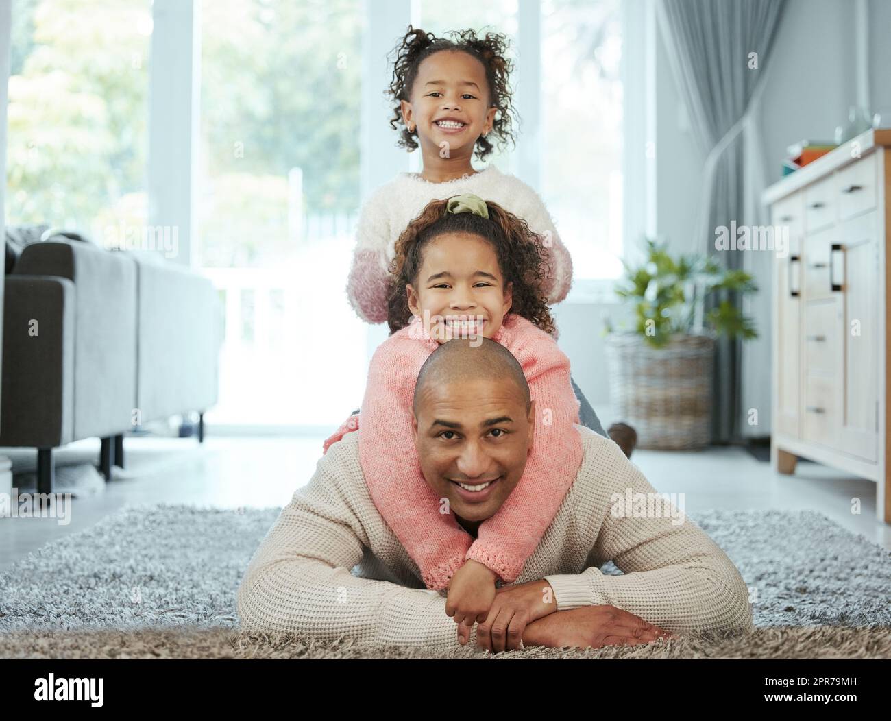 Avere una famiglia meravigliosa come la mia è veramente una benedizione: Un uomo che si lega con le sue due figlie a casa. Foto Stock