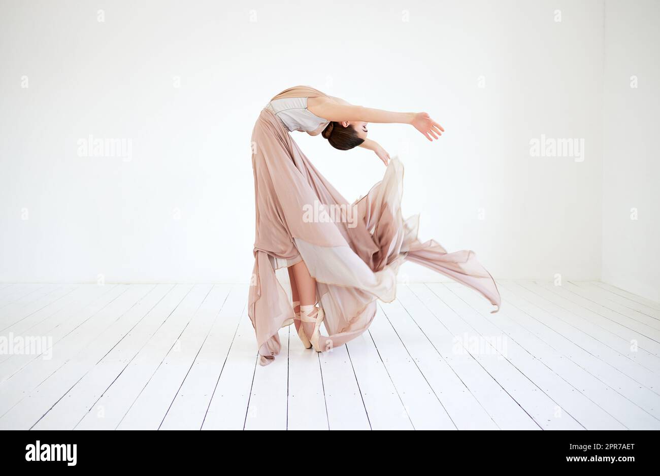 La sua routine racconta una storia. Scatto a tutta lunghezza di una ballerina femminile attraente e giovane che pratica nel suo studio di danza. Foto Stock