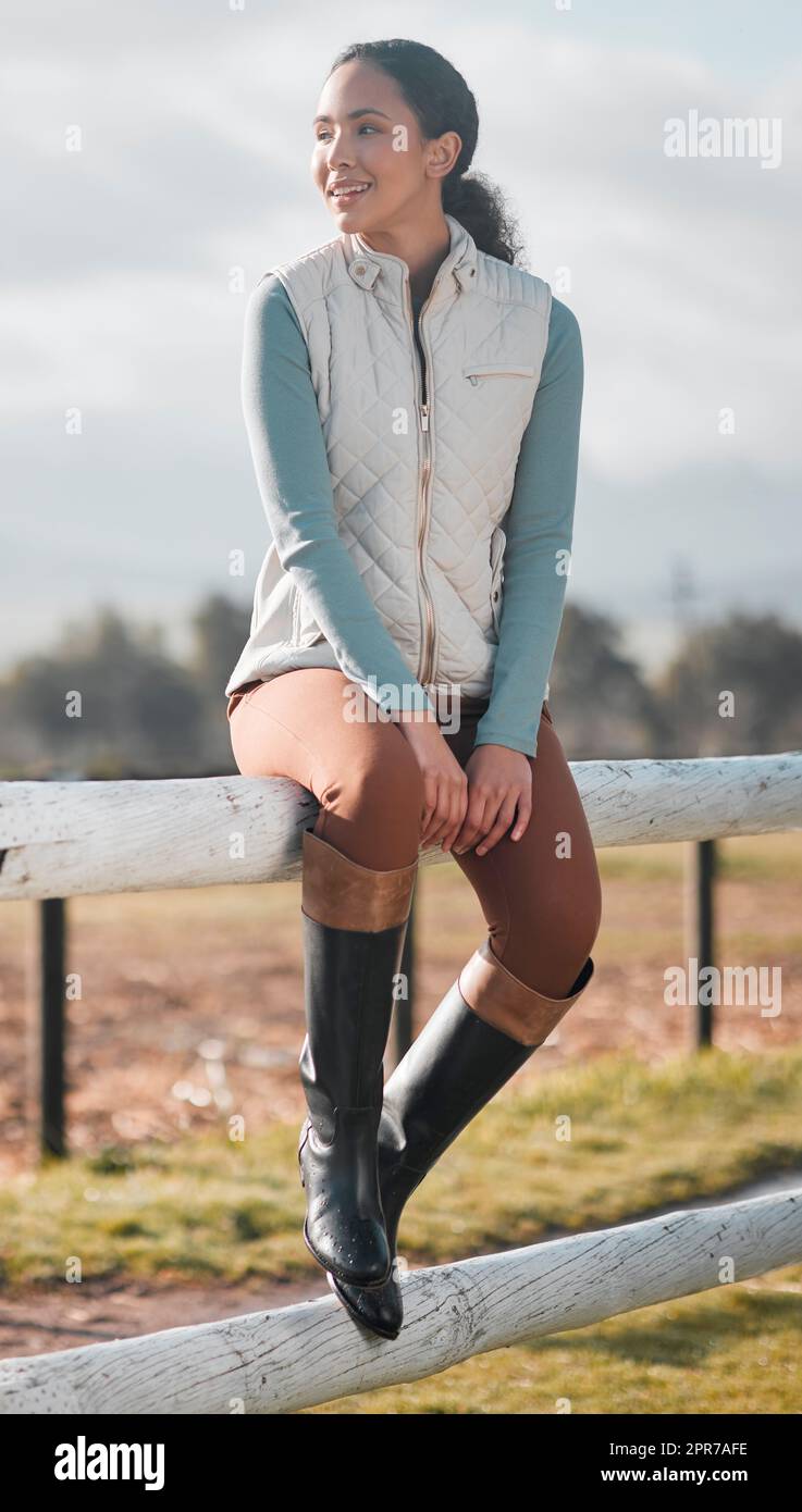 Questa è la vita. Ripresa a tutta lunghezza di una giovane donna attraente seduta da sola su una recinzione di legno in una fattoria. Foto Stock