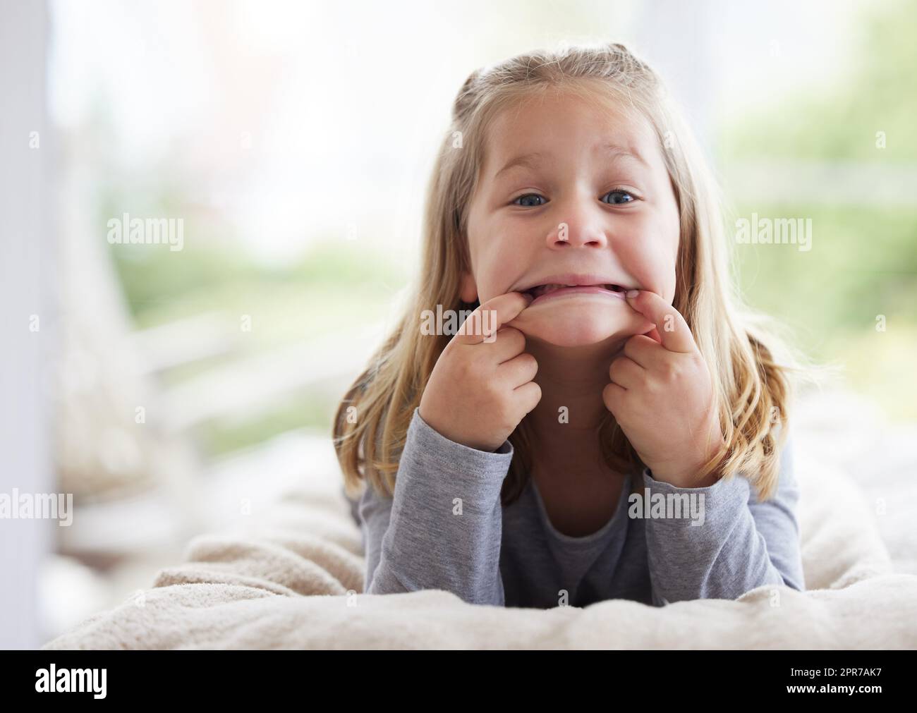 Ti ho fatto guardare, una ragazza che fa volti divertenti a casa. Foto Stock