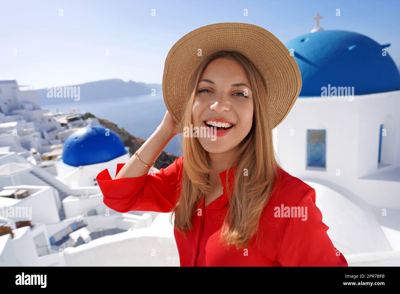 Primo piano di ragazza allegra a Oia pittoresco villaggio greco di Santorini Island. Ritratto di giovane donna che si diverte in Grecia, Europa. Foto Stock