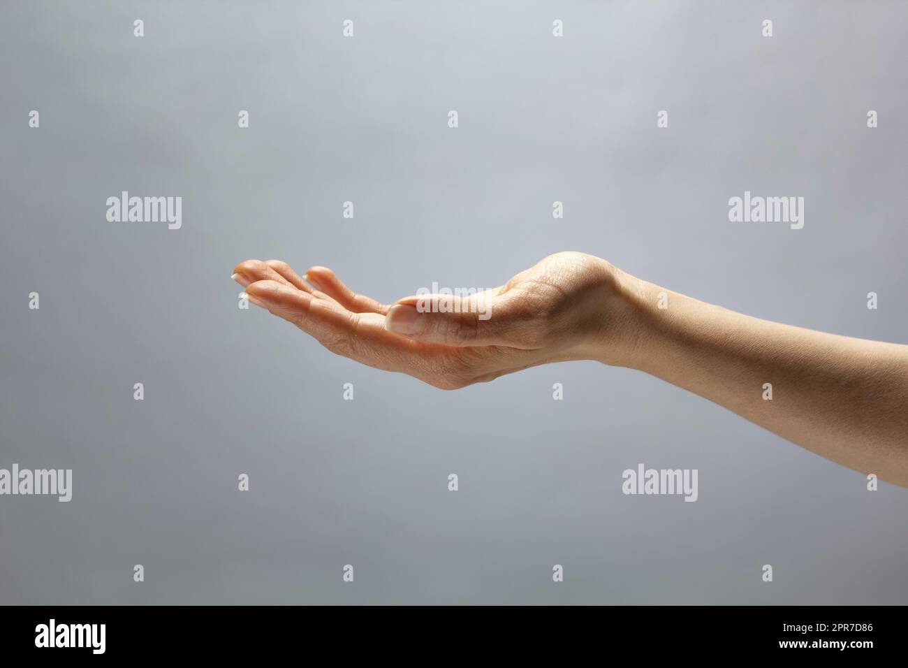 La mano di una donna mostra un gesto di un oggetto invisibile su uno sfondo bianco isolato. Posto per la pubblicità. Copia spazio. Foto Stock