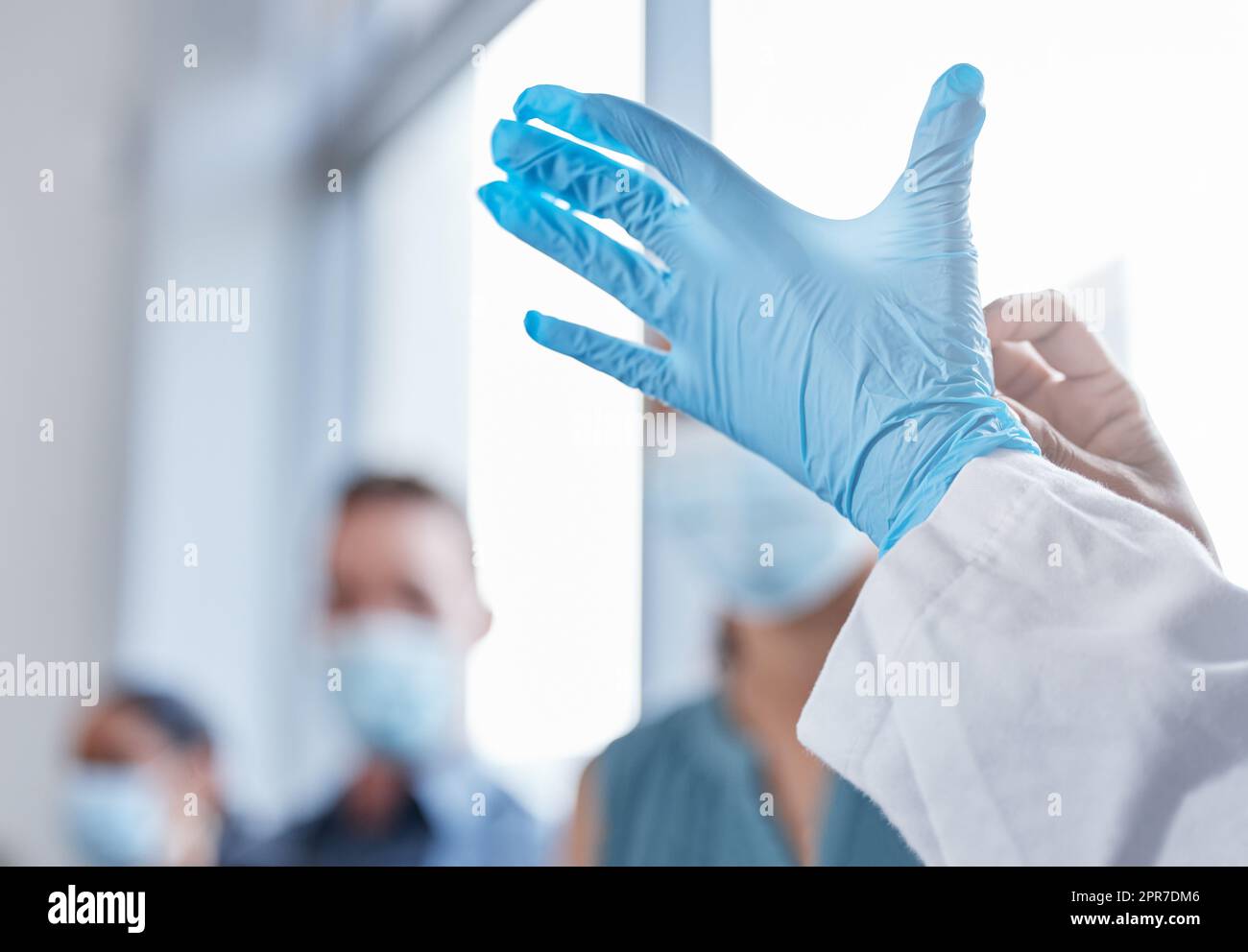 La sicurezza prima di tutto. Primo piano di un medico irriconoscibile che indossa guanti durante il trattamento dei pazienti covidi in ospedale. Foto Stock