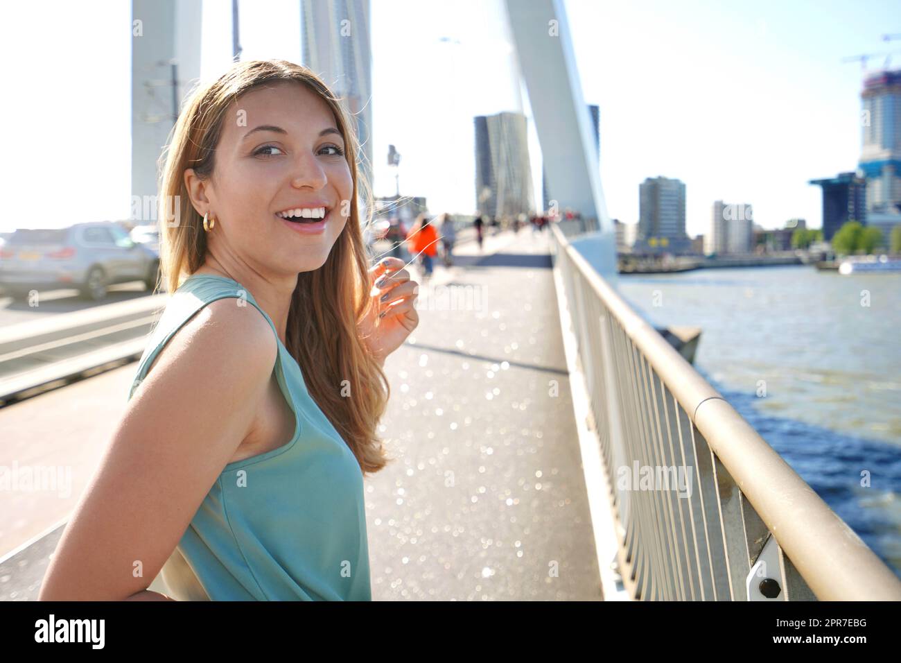 Ritratto di ragazza vivace si gira e sorridere alla macchina fotografica con moderno paesaggio urbano sullo sfondo, Rotterdam, Paesi Bassi Foto Stock