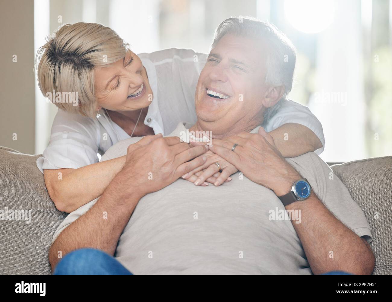 Essere una famiglia significa essere parte di qualcosa di meraviglioso: Una coppia matura seduta sul divano a casa. Foto Stock