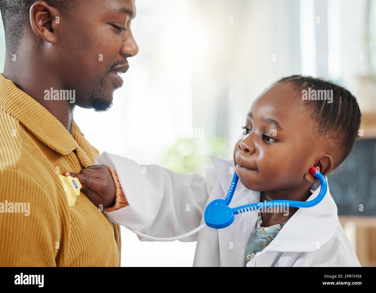 Respira per me. Una bambina che finge di essere un medico mentre gioca con suo padre. Foto Stock