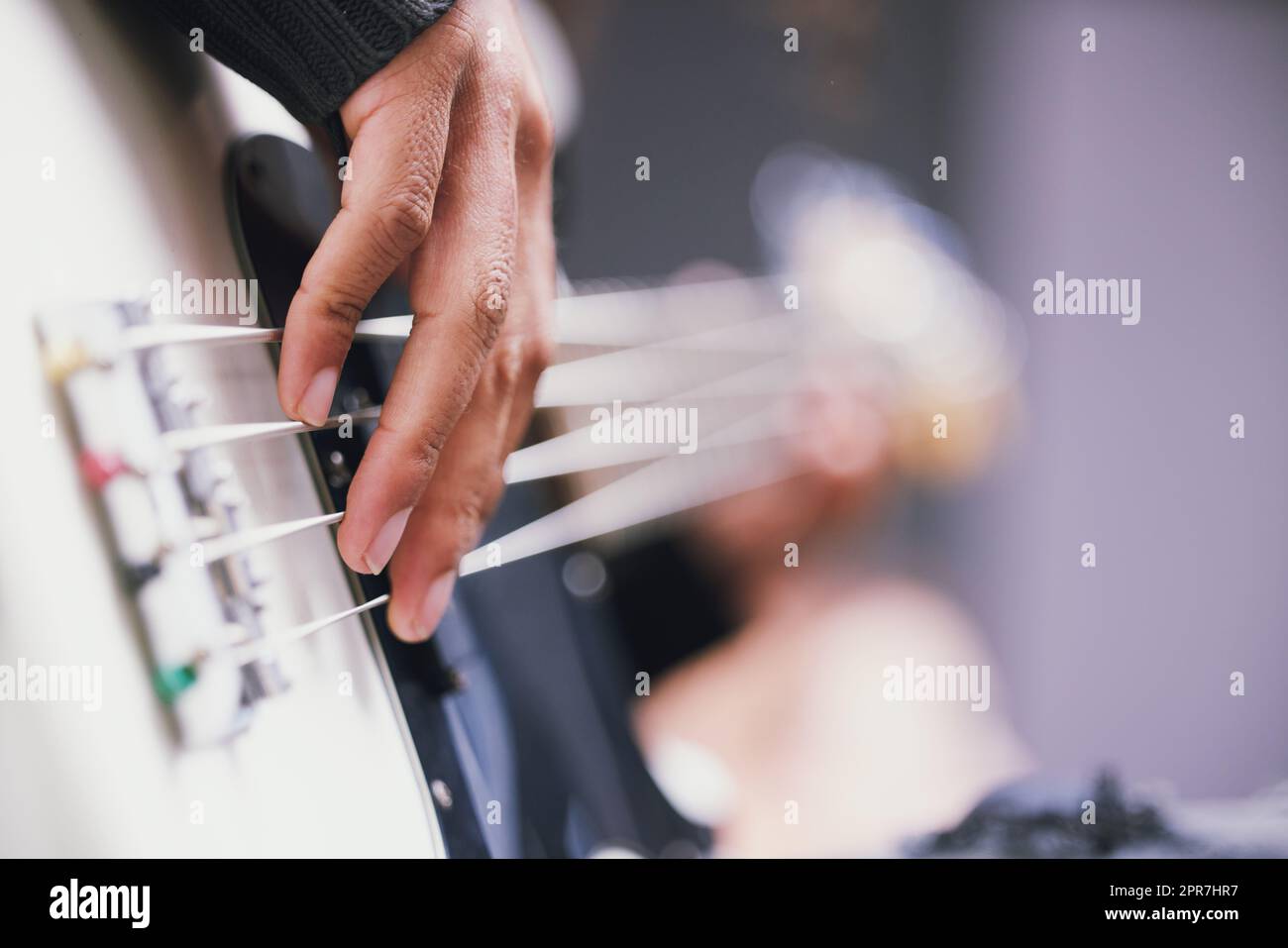 Vivere una vita piena di musica. Un uomo irriconoscibile che suona la chitarra in uno studio di musica durante il giorno. Foto Stock