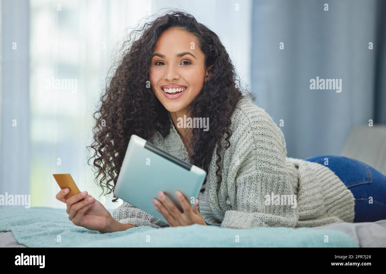 Ora i pagamenti online sono così semplici: Una giovane donna che usa il suo tablet digitale per effettuare pagamenti con carta online. Foto Stock